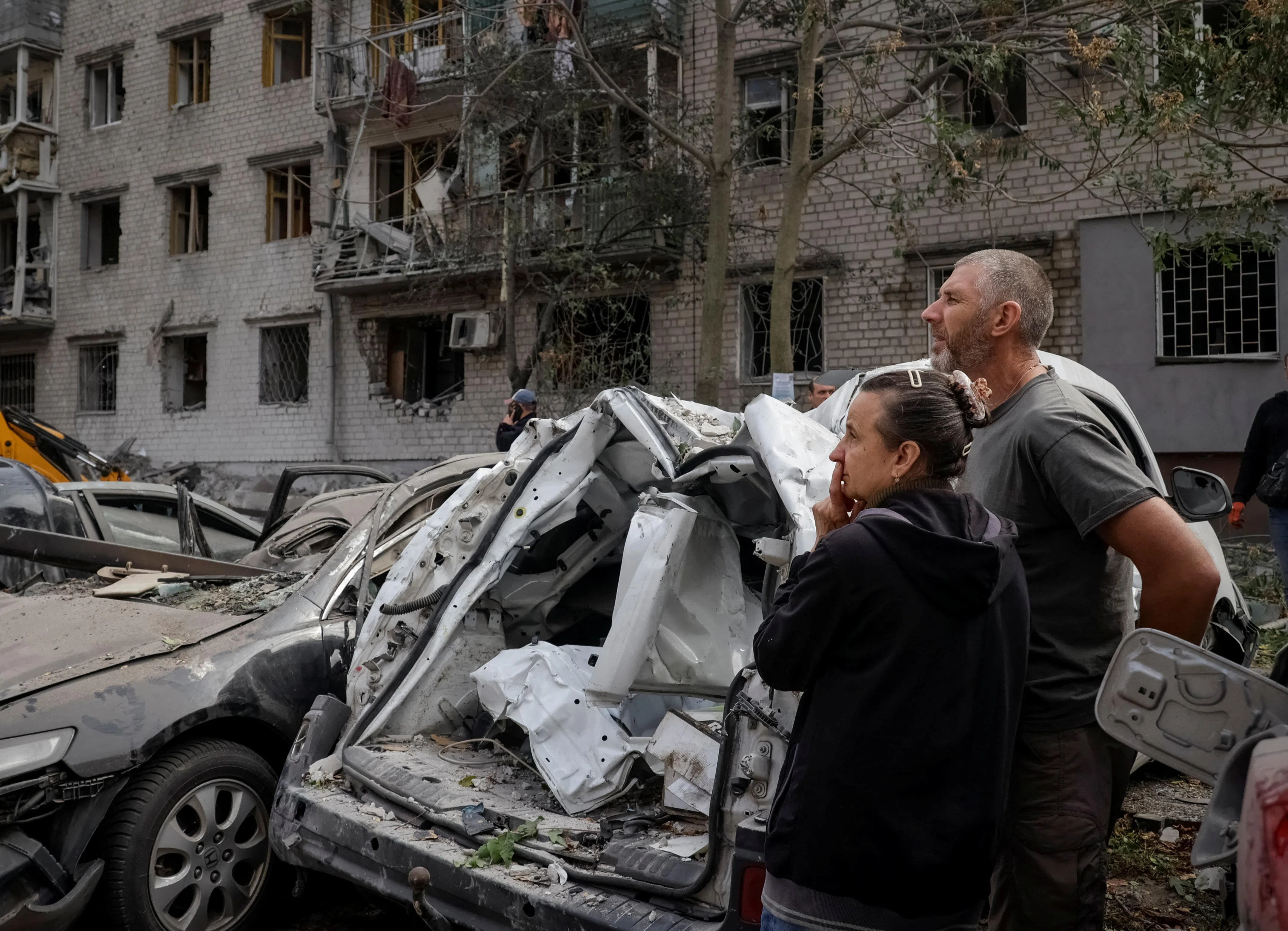 Residents at the site of a Russian strike on an apartment building in the town of Kremenchuk, in Ukraine’s Poltava region, on Oct 7.