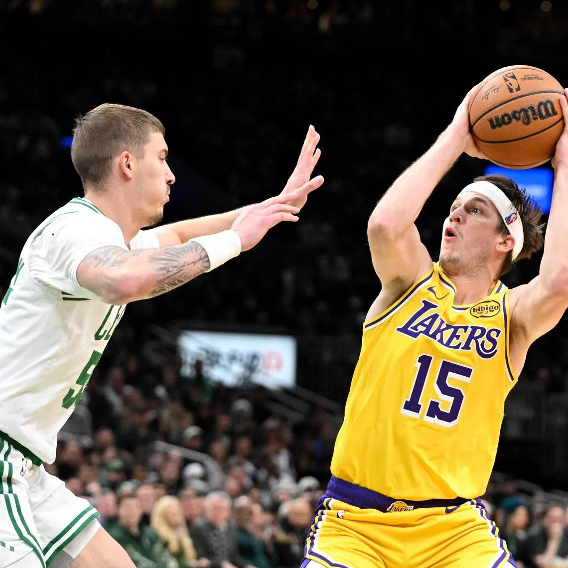 Austin Reaves of the Los Angeles Lakers attempts a shot past Baylor Scheierman of the Boston Celtics during the first half at the TD Garden.