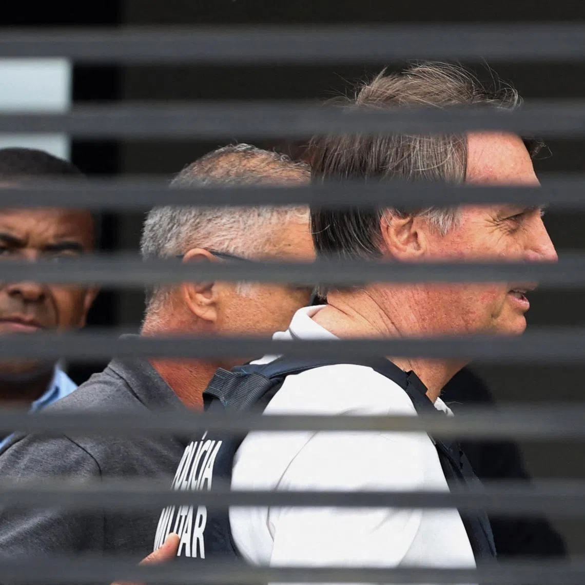 Former Brazilian President Jair Bolsonaro arrives home to begin serving house arrest following authorization by Supreme Court Justice Alexandre de Moraes, after Bolsonaro was convicted by a Supreme Court majority of plotting a coup to remain in power after losing the 2022 election, in Brasilia, Brazil March 27, 2026. REUTERS/Adriano Machado