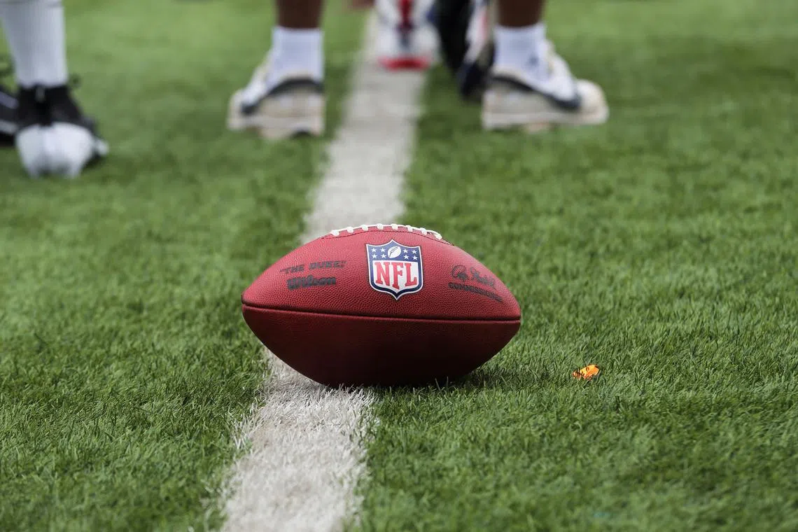 FILE PHOTO: A ball with the National Football League (NFL) logo is spotted on a lush green field during a drill exercise at the talent identification camp for the NFL, in Lagos, Nigeria, June 17, 2024. REUTERS/Akintunde Akinleye/File Photo