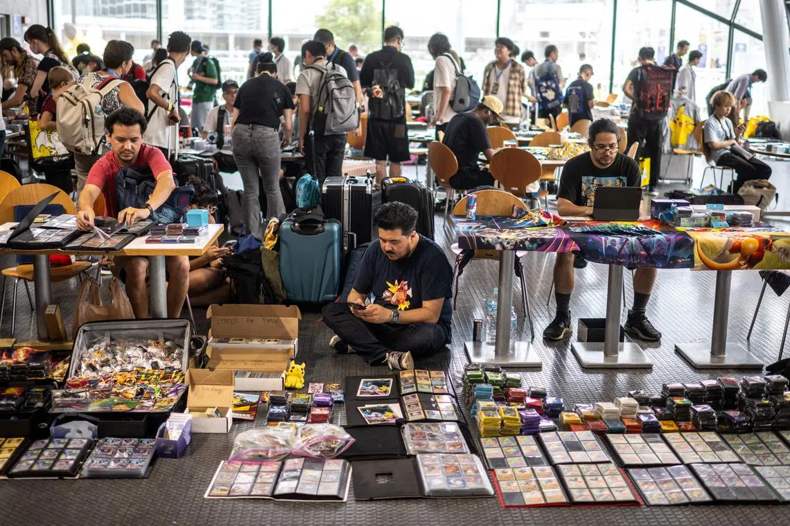 Pokémon fans display cards and products at the dedicated trade area during the 2023 Pokémon World Championships in Yokohama on August 11, 2023. (Photo by Philip FONG / AFP)