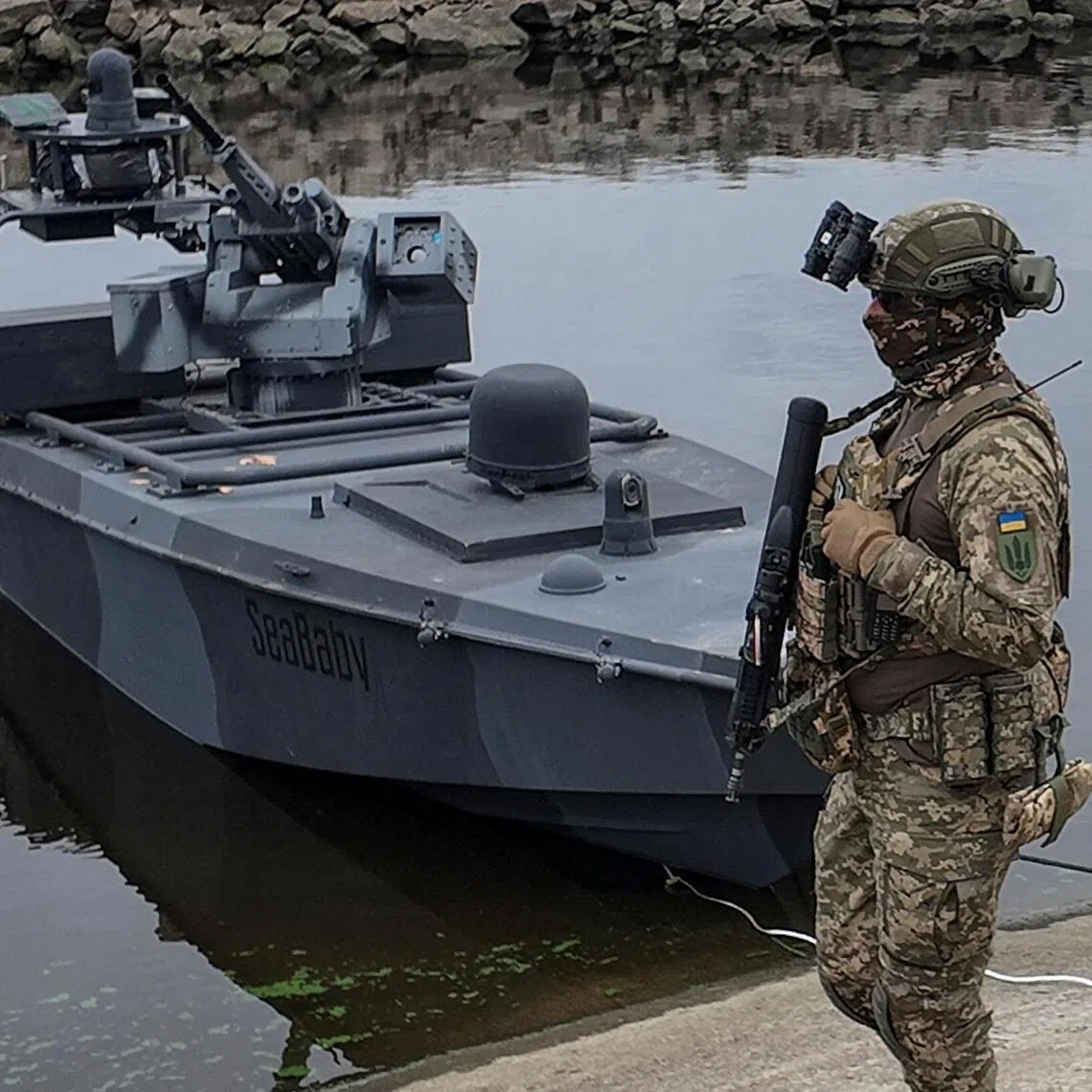 A serviceman of Ukraine's SBU security service standing next to the latest version of the country's "Sea Baby" naval drone in October 2025.