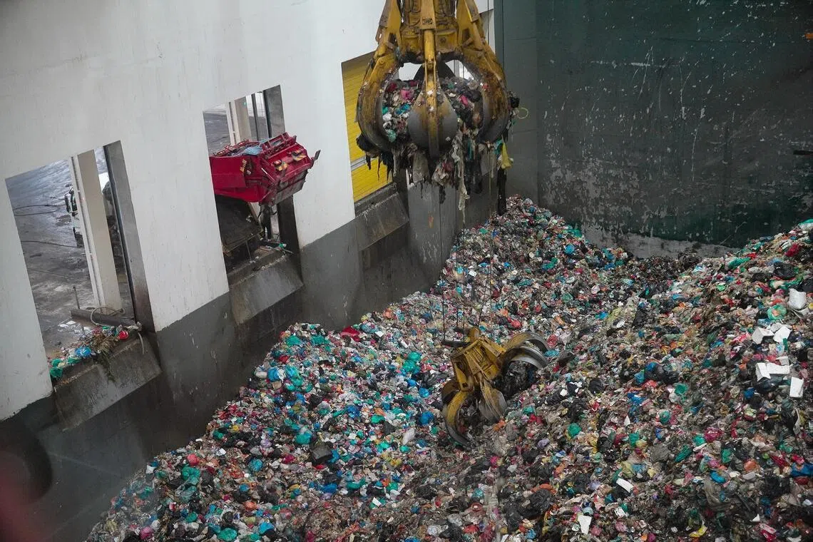 Two claws collect drained rubbish to be fed into the incinerator for power generation.