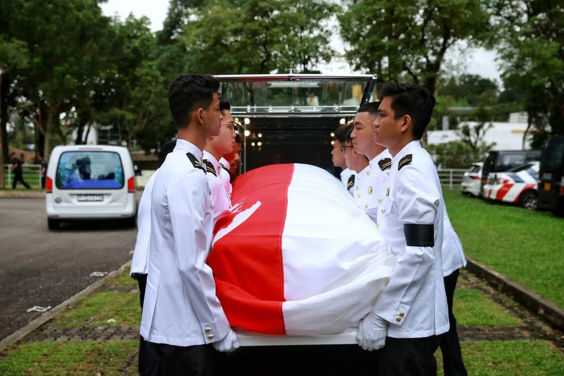 Transfer of the casket from the hearse to the SCDF carriage during the ceremonial procession at Mandai Crematorium and Columbarium.