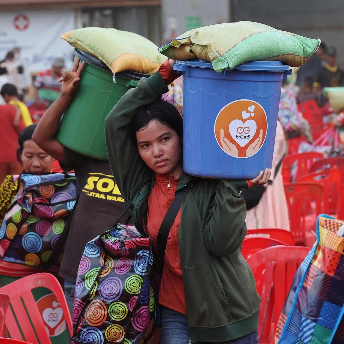 People carrying supplies at Batthkav refugee camp in Cambodia on Dec 12, amid ongoing border clashes between Thailand and Cambodia.