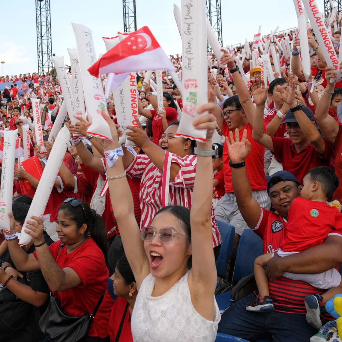 Spectators doing the Kallang Wave during the National Day Parade at the Padang. With a population now having bought into the aspirations of the National Pledge, realising it through lived experiences is needed for the next stages of nation-building, says the writer.