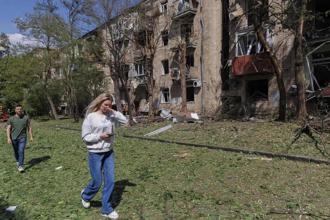 People walking past the scene of an earlier Russian bomb attack on a residential building in Kharkiv, in northeastern Ukraine, on May 5.