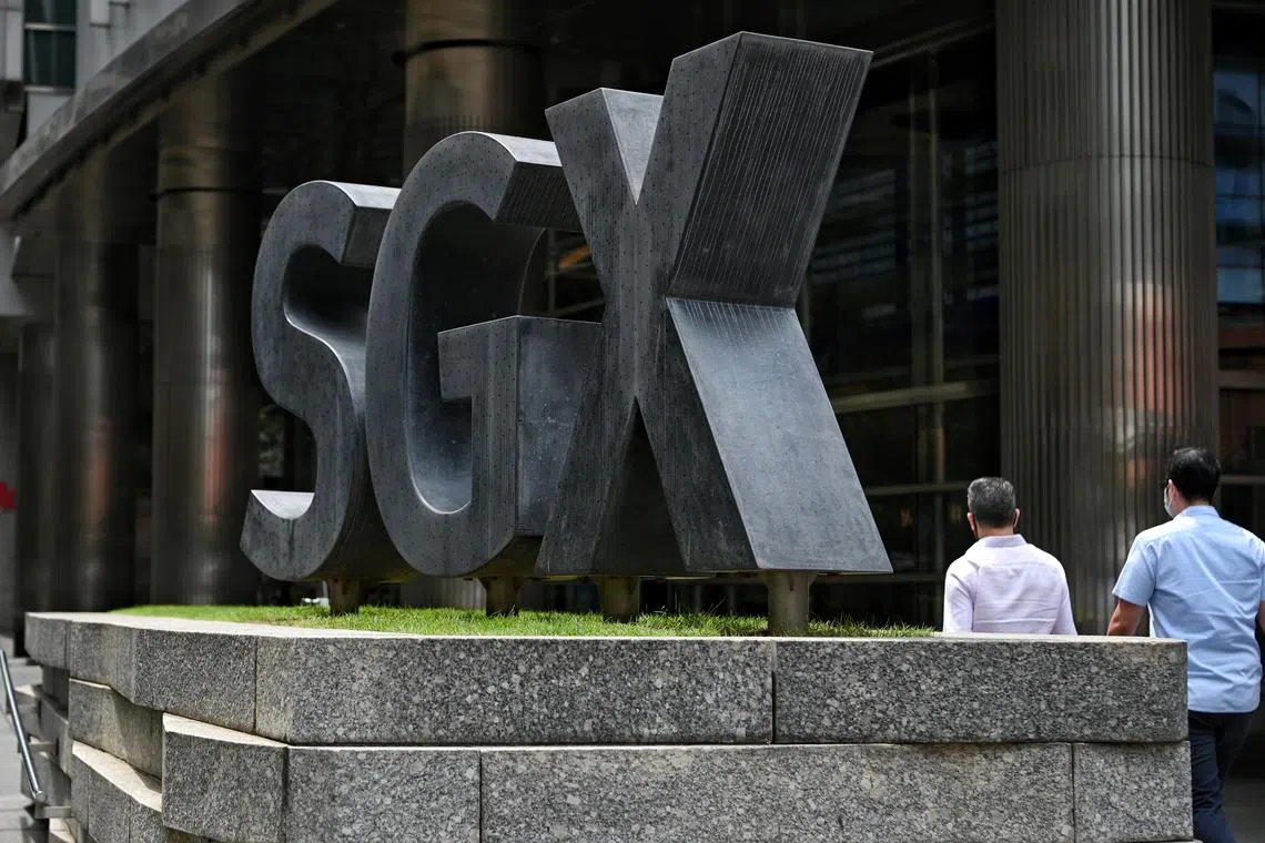 Office workers walking past the SGX logo outside the SGX Centre 1 located along Shenton Way on 6 December 2021.
