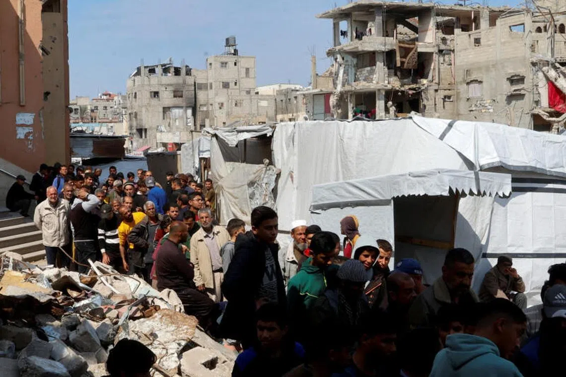 Palestinians gather to receive bread from a bakery, in Khan Younis, in the southern Gaza Strip, March 9, 2025. REUTERS/Hatem Khaled TPX IMAGES OF THE DAY
