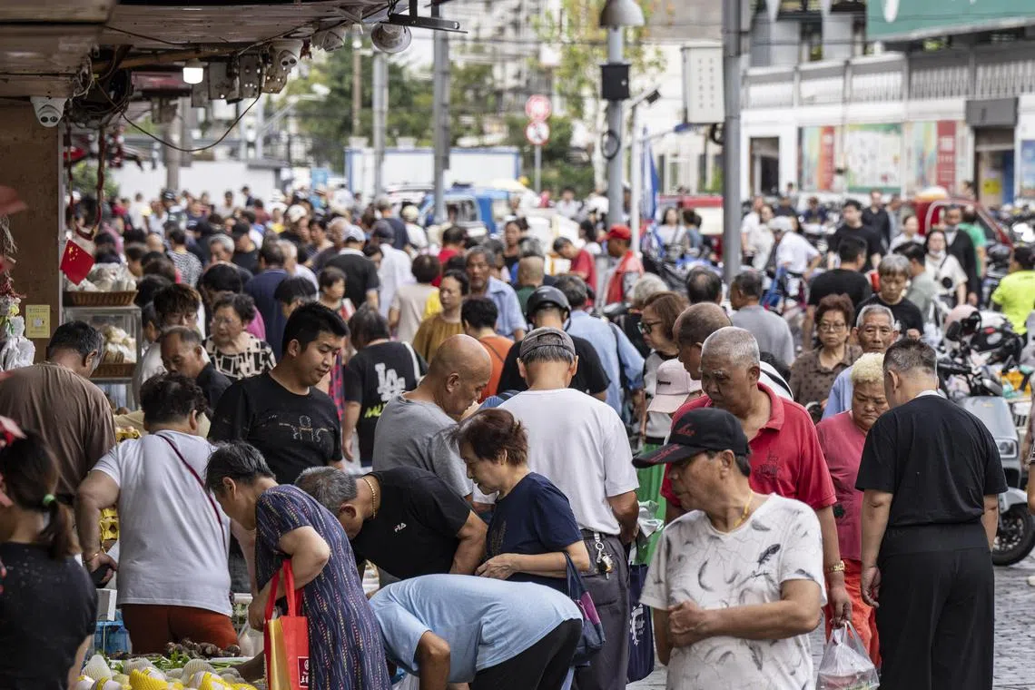 Residents do their morning shopping at a produce market in Shanghai, on Sept 19.