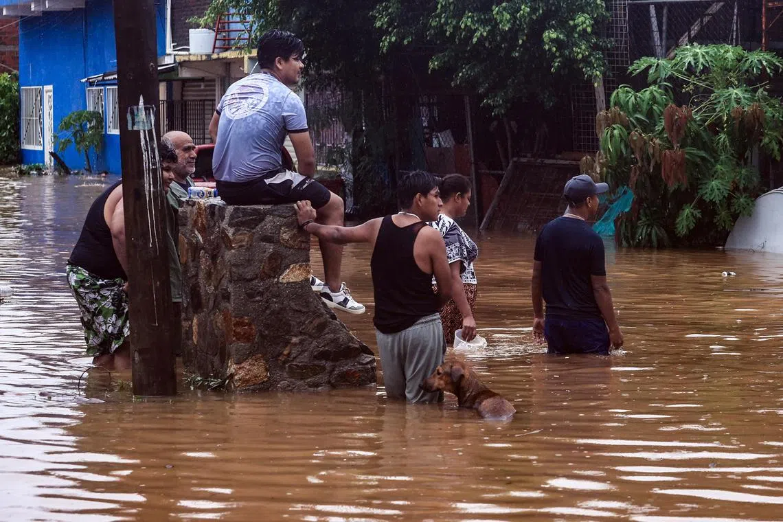 People observe a house damaged by Hurricane John's passage in Acapulco, Mexico, 26 September 2024. State authorities have raised the death toll to 10 in southern Mexico as a result of Hurricane John, a Category 1 storm, which is moving through central Mexico's Pacific coast, adding two victims in the last few hours.  EPA-EFE/David Guzman