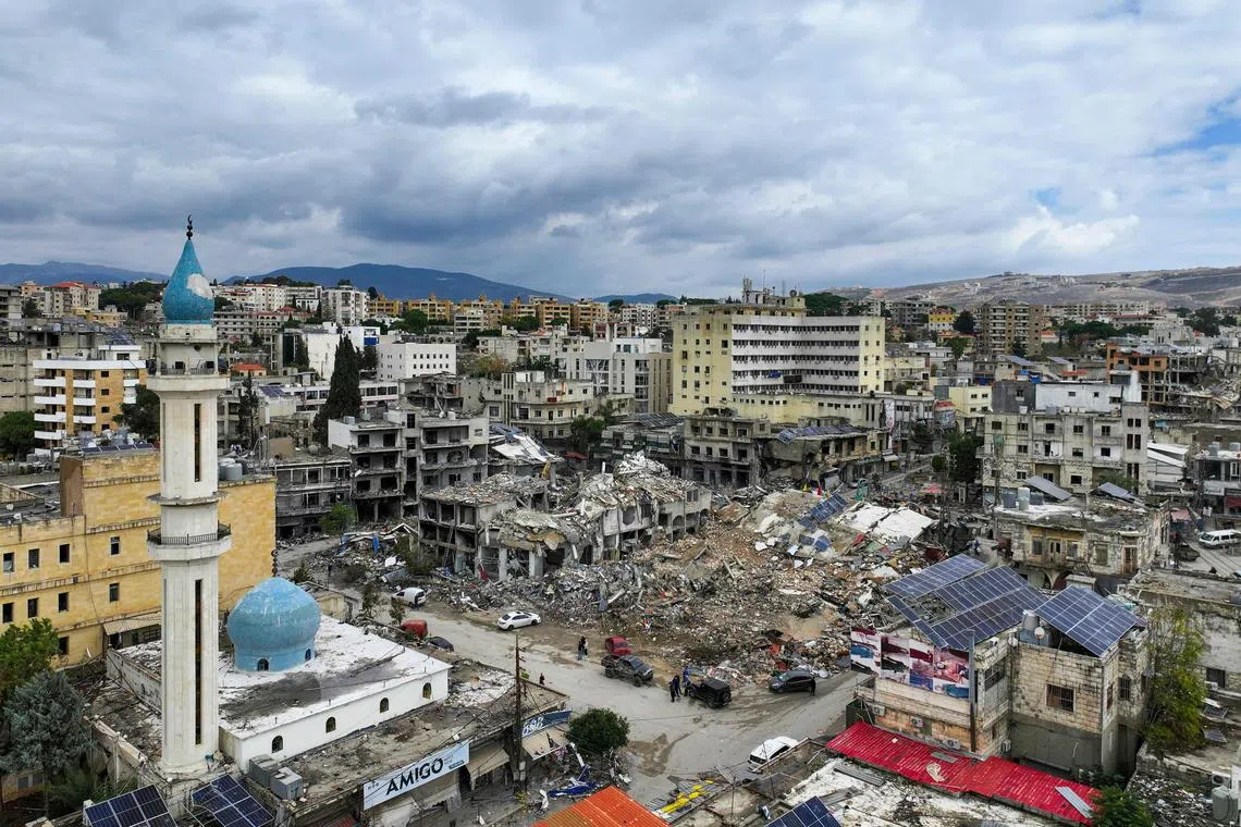 TOPSHOT - This aerial view taken a day after a ceasefire between Israel and Hezbollah took hold shows people inspecting the damage in the southern Lebanese city of Nabatieh on November 28, 2024. Since the ceasefire took effect on November 27, tens of thousands of Lebanese who fled their homes headed back to their towns and villages, only to find scenes of devastation. (Photo by AFP)
