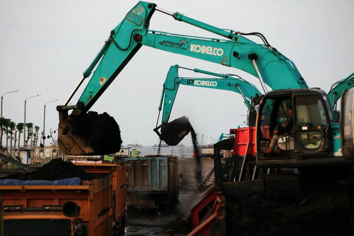 FILE PHOTO: Heavy machinery unload coal from barges into trucks to be distributed, at the Karya Citra Nusantara port in North Jakarta, Indonesia, January 13, 2022. Picture taken January 13, 2022. REUTERS/Willy Kurniawan/File Photo