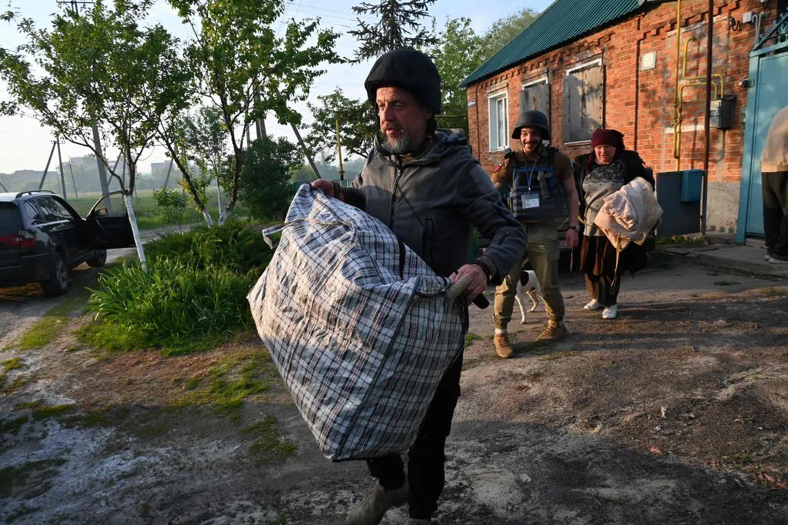 Ukrainian volunteers helping residents evacuate from settlements in the north of Ukraine's Kharkiv region, on May 10.