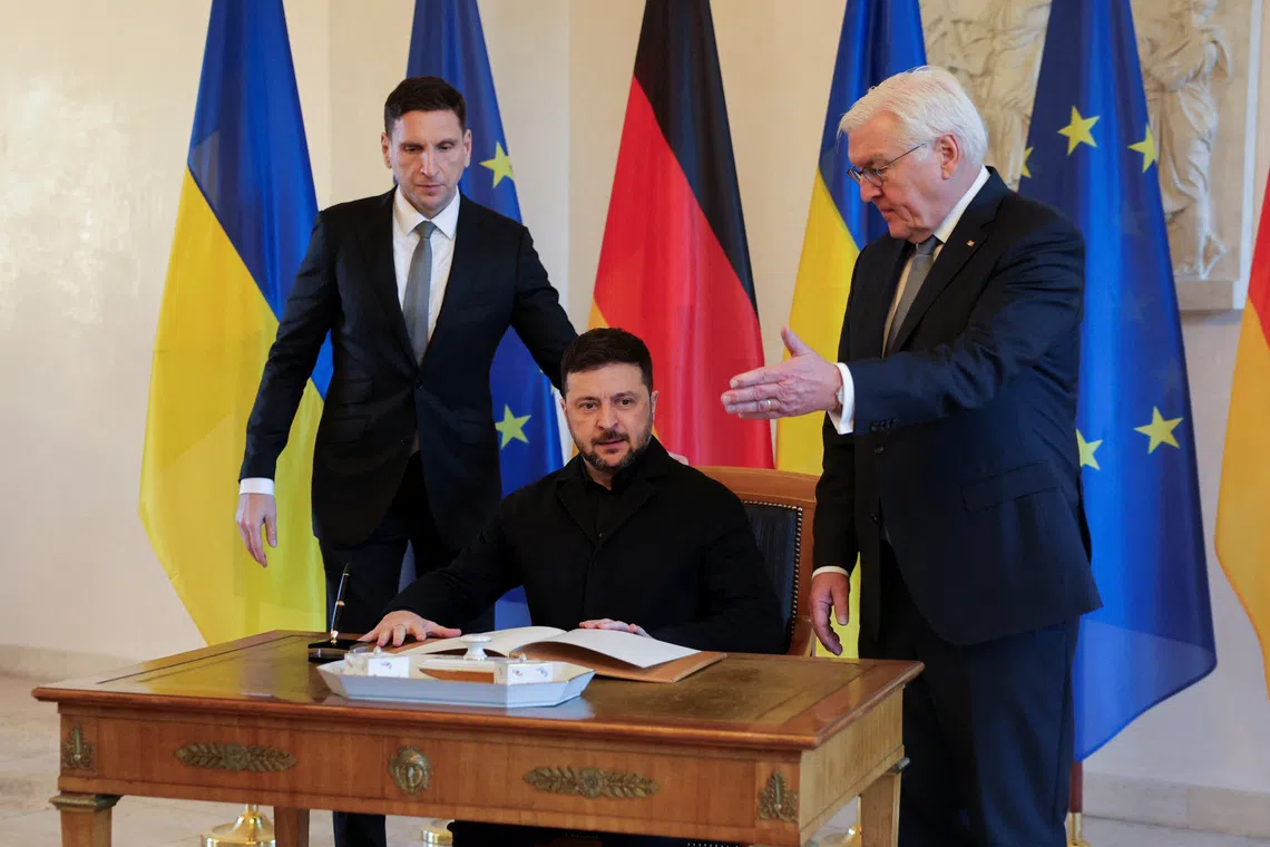 German President Frank-Walter Steinmeier gestures next to Ukrainian President Volodymyr Zelenskiy after he signed a guest book at Bellevue Palace in Berlin, Germany, December 15, 2025. REUTERS/Fabrizio Bensch
