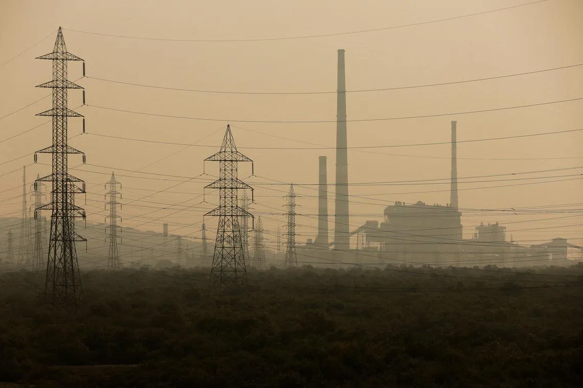 Power grids are seen next to a chemical factory on a smoggy morning in Mumbai, India, November 13, 2023. REUTERS/Francis Mascarenhas