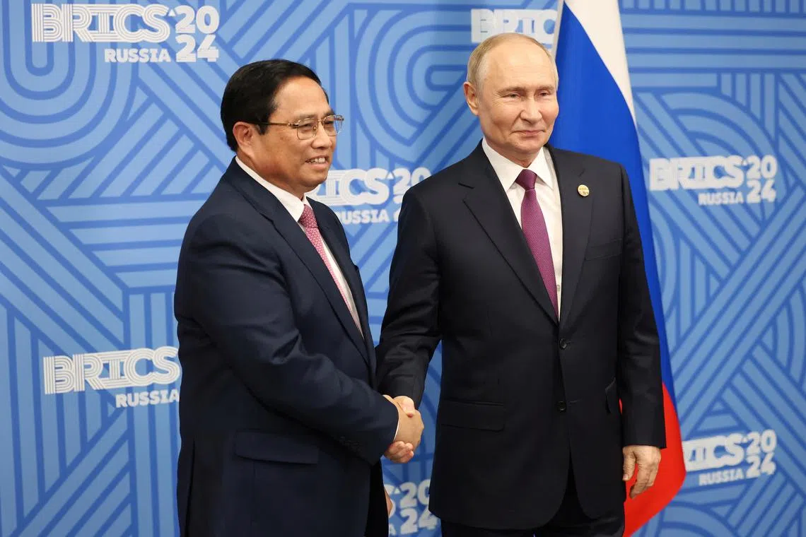 Russian President Vladimir Putin shakes hands with Vietnamese Prime Minister Pham Minh Chinh during a meeting on the sidelines of the BRICS summit in Kazan, Russia October 24, 2024. Sputnik/Alexander Kazakov/Pool via REUTERS