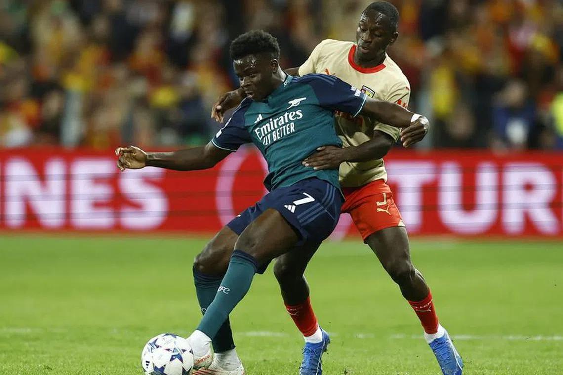 Soccer Football - Champions League - Group B - RC Lens v Arsenal - Stade Bollaert-Delelis, Lens, France - October 3, 2023  Arsenal&#039;s Bukayo Saka in action with RC Lens&#039; Deiver Machado REUTERS/Christian Hartmann
