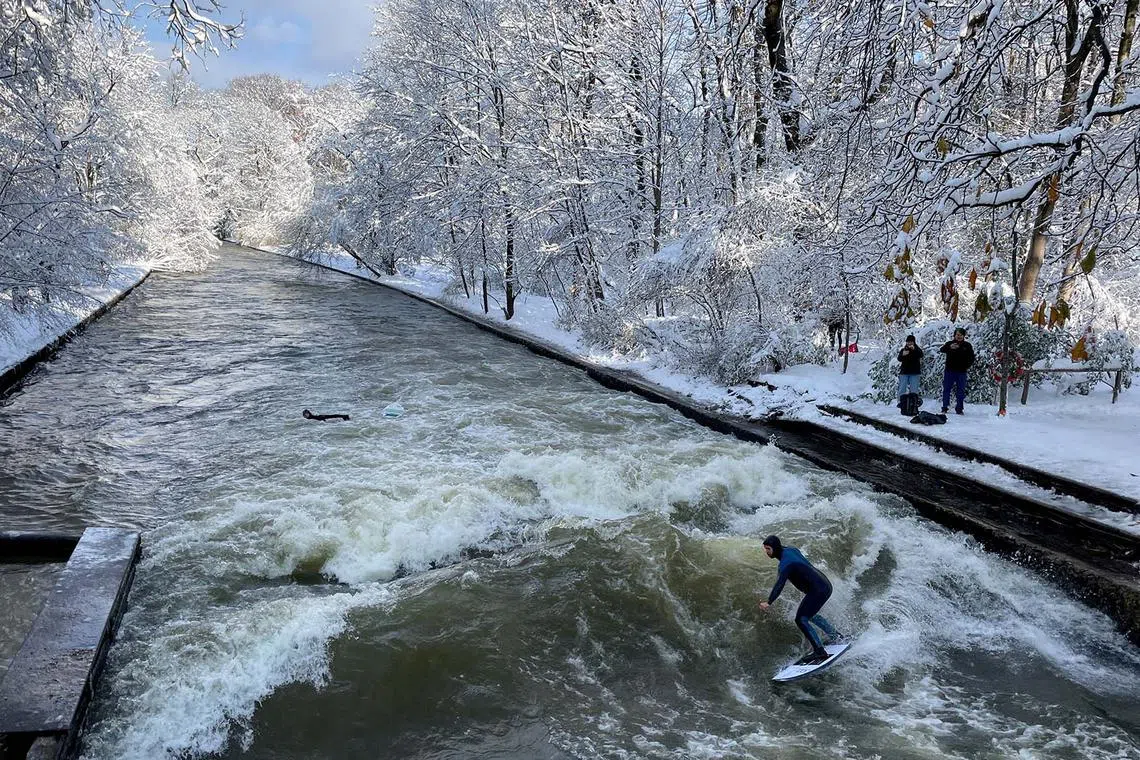 A man surfing the waves on the Eisbach river a day after heavy snowfall hit Bavaria and its capital Munich, Germany, Dec 3, 2023. 