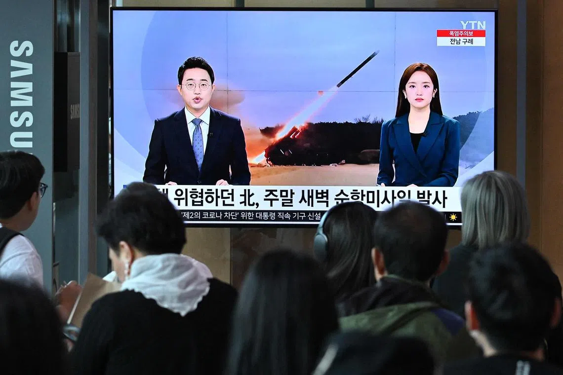 TOPSHOT - People watch a television screen showing a news broadcast with file footage of a North Korean missile test, at a railway station in Seoul on July 22, 2023. North Korea has fired "several cruise missiles" into the Yellow Sea between China and the Korean peninsula, South Korea's Joint Chiefs of Staff said on July 2023. (Photo by Jung Yeon-je / AFP)