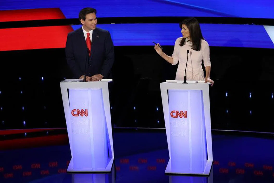 Florida Governor Ron DeSantis smiles as Former U.S. Ambassador to the United Nations Nikki Haley speaks as they participate in the Republican candidates' presidential debate hosted by CNN at Drake University in Des Moines, Iowa, U.S. January 10, 2024. REUTERS/Mike Segar