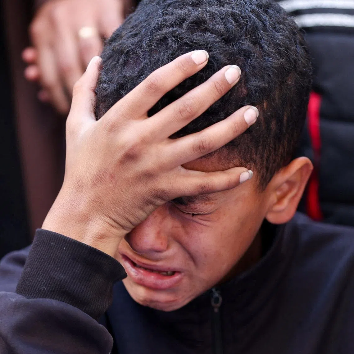 A boy reacts during the funeral of Palestinians who, according to medics, were killed in an Israeli strike, in Gaza City, March 30, 2026. REUTERS/Dawoud Abu Alkas