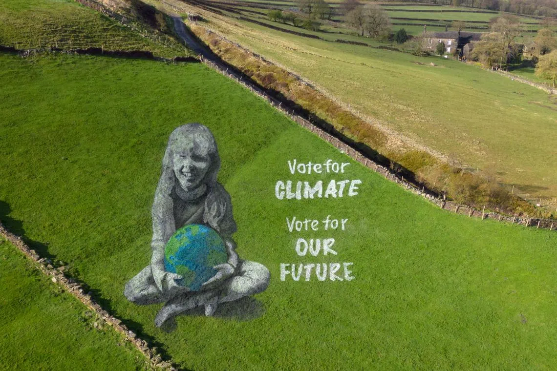 A 50-metre anamorphic field painting of a girl holding the Earth, created by artists from 'Sand In Your Eye' to mark Earth Day, adorns a hillside above Hebden Bridge, England on April 19, 2024. The artwork, was created to coincide with Earth Day 2024 and aims to encourage people to consider the climate when voting in the UK's forthcoming elections.