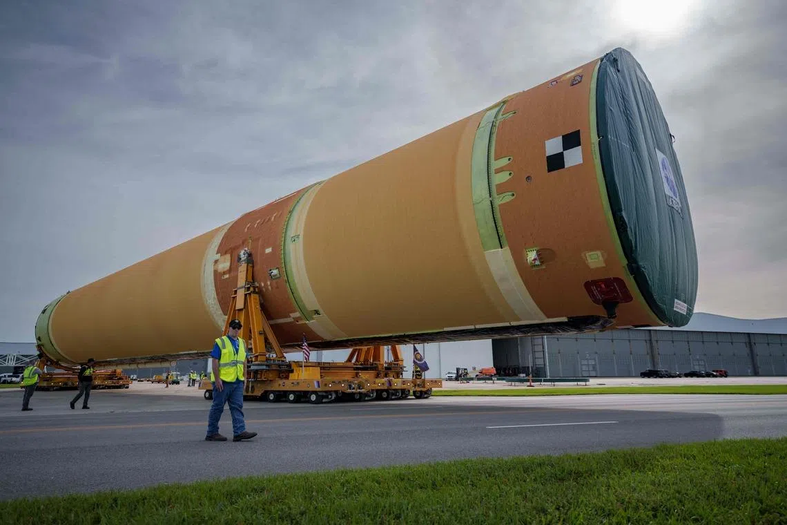 TOPSHOT - NASA staff help roll out the largest section of the agency's Space Launch System (SLS) rocket for the Artemis III at NASA's Michoud Assembly Facility in New Orleans, on April 20, 2026. The NASA Artemis III mission is currently scheduled for launch in 2027. (Photo by Matthew HINTON / AFP)