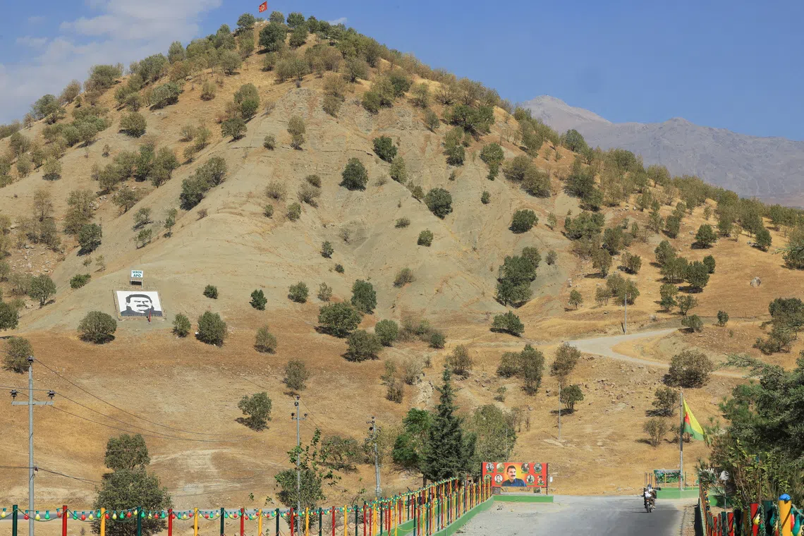 A portrait of jailed Kurdistan Workers Party (PKK) leader Abdullah Ocalan and a sign with the words \"Serok Apo,\" are displayed on a hillside in the Qandil mountains, Iraq, October 26, 2025. REUTERS/Thaier Al-Sudani