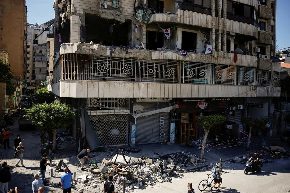 People and members of press look at a damaged building at the site of an Israeli strike on central Beirut's Bachoura neighbourhood, amid ongoing hostilities between Hezbollah and Israeli forces, in Beirut, Lebanon October 3, 2024. REUTERS/Louisa Gouliamaki
