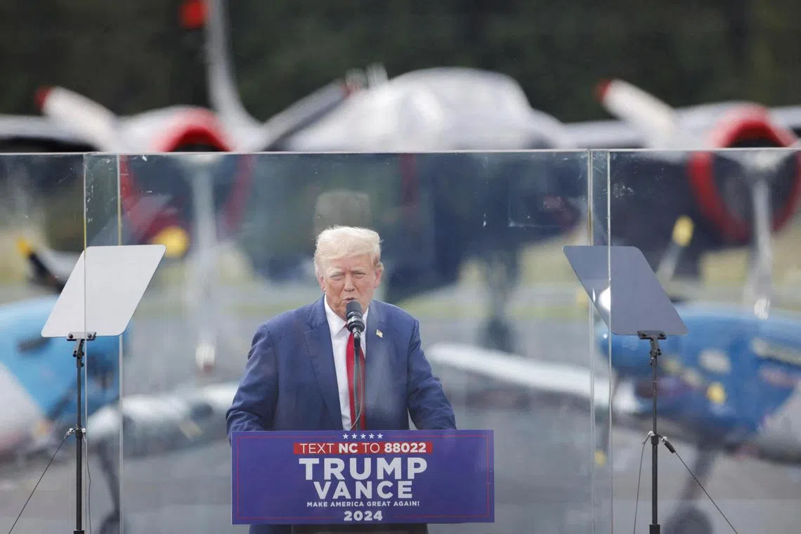 Donald Trump speaks from a bulletproof glass housing during a campaign rally in North Carolina.