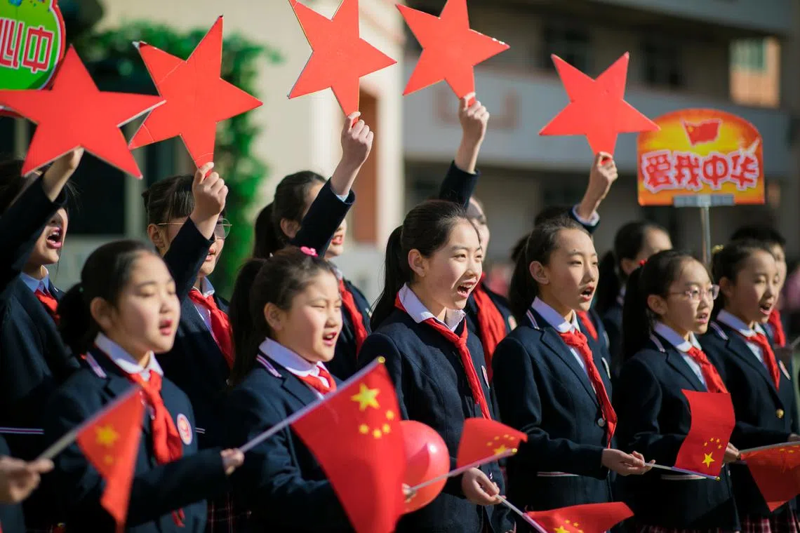 FILE PHOTO: Students hold Chinese flags and cutouts of red stars as they perform a song titled \"Me and my country\", at a ceremony marking the primary school's new semester in Hohhot, Inner Mongolia Autonomous Region, China February 28, 2019.  REUTERS/Stringer/File photo