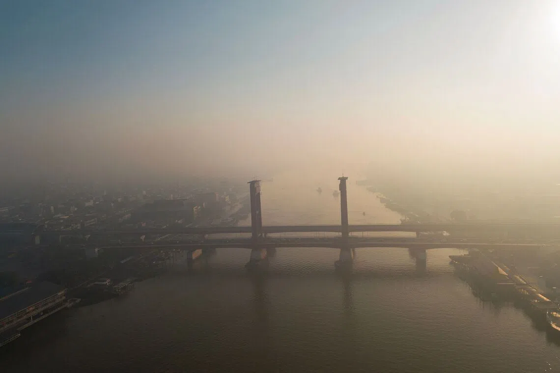 TOPSHOT - An aerial view shows the Ampera Bridge over the Musi river shrouded in haze caused by forest fires in Palembang, South Sumatra on September 3, 2026. (Photo by AL ZULKIFLI / AFP)