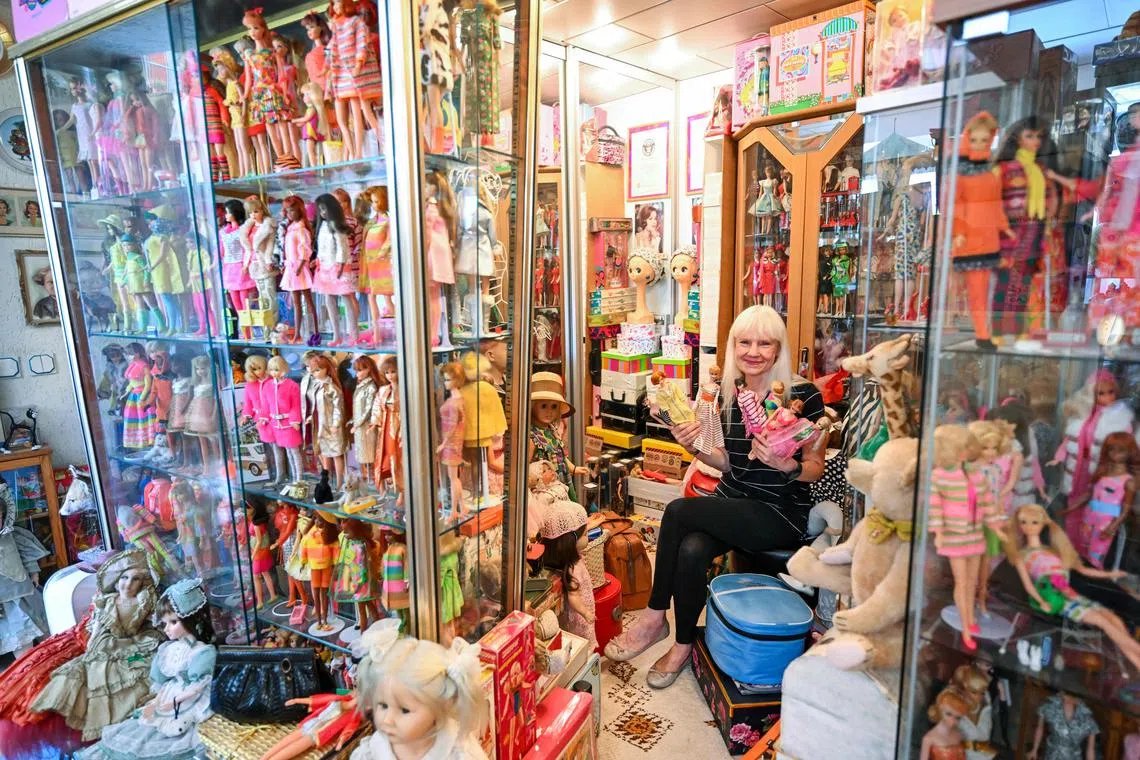 Barbie collector Bettina Dorfmann holds some of her rare Barbies as she sits among hundres of dolls at her "Barbie clinic" in Germany.