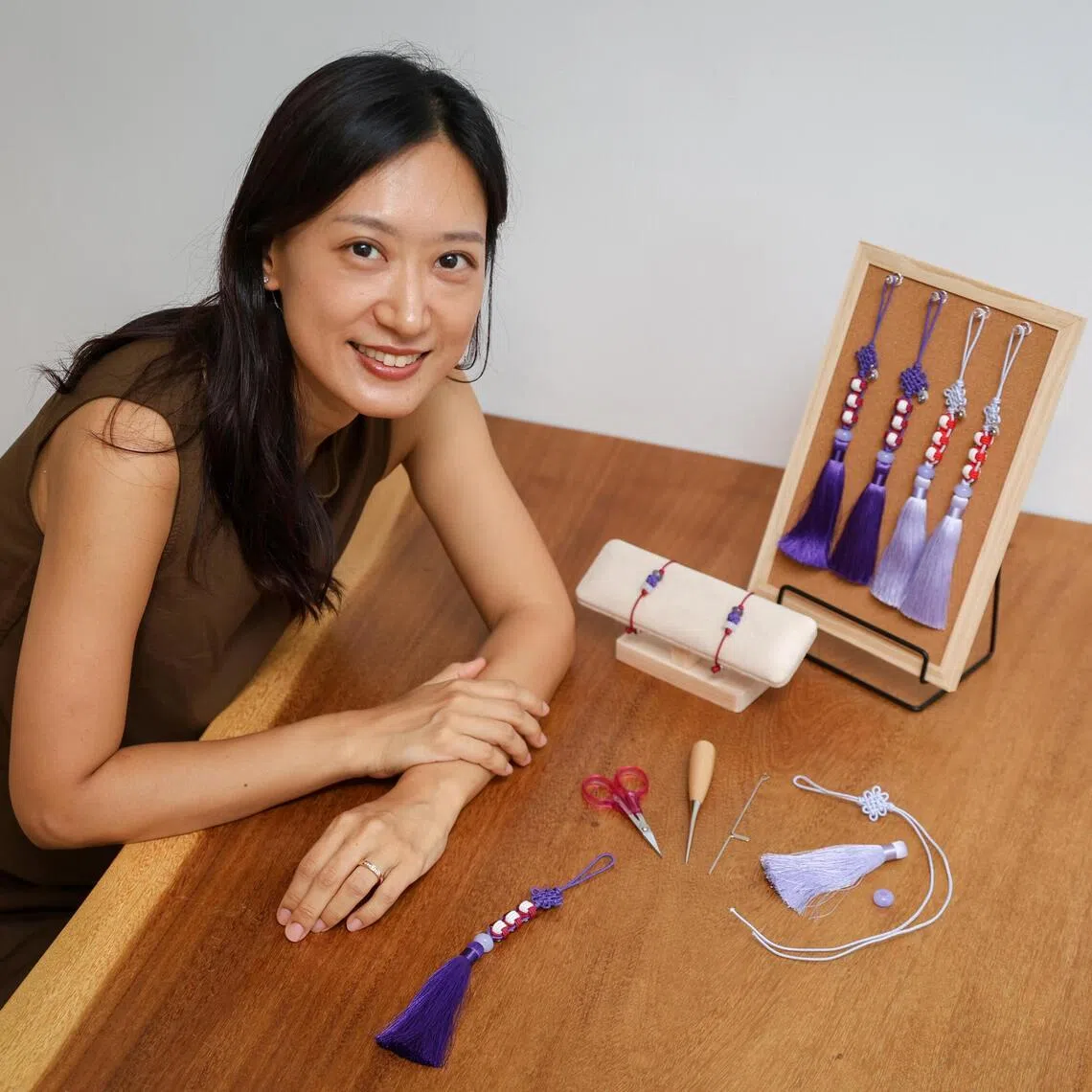 ST20260525_202697800794/Sarah Lee/jsknot04

Ms Suna Kim, 40, who sells traditional Korean knot (maedeup) accessories, pictured with her BTS-inspired norigae and bracelets in her home on May 25, 2026. ST PHOTO: SARAH LEE