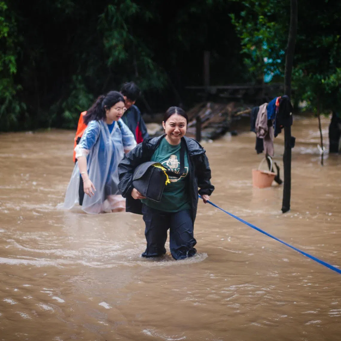 NTU students Toh Tian Ji (in green shirt) and Faith Peh (in poncho) were caught in heavy rain and floods when they visited a village in Mae Pa.