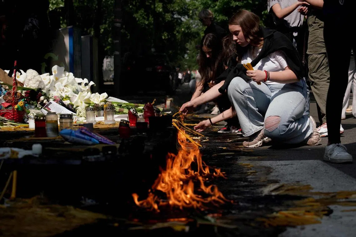 People lay flowers and candles for the victims of a school shooting outside the school in Belgrade on Friday.