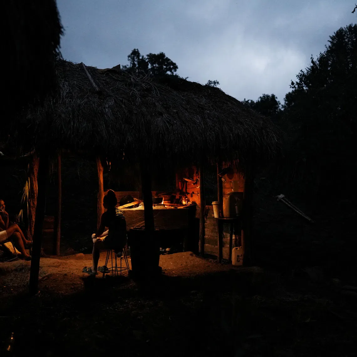 People prepare dinner at an outside kitchen near the village of Santo Domingo, in the Sierra Maestra, Cuba, October 31, 2025. REUTERS/Alexandre Meneghini