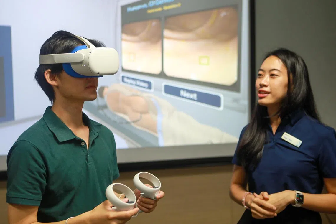 ST20230314_202306077952/occancer14/Ryan Chiong

Medtronic sales representative Joyce Yoon (right) explaining to ST reporter Osmond Chia (left) how an AI-assisted colonoscopy will be like with the use of a virtual reality (VR) device in Sengkang Hospital on March 14, 2023. Users of the VR device are tested on identifying polyps in the colon.
