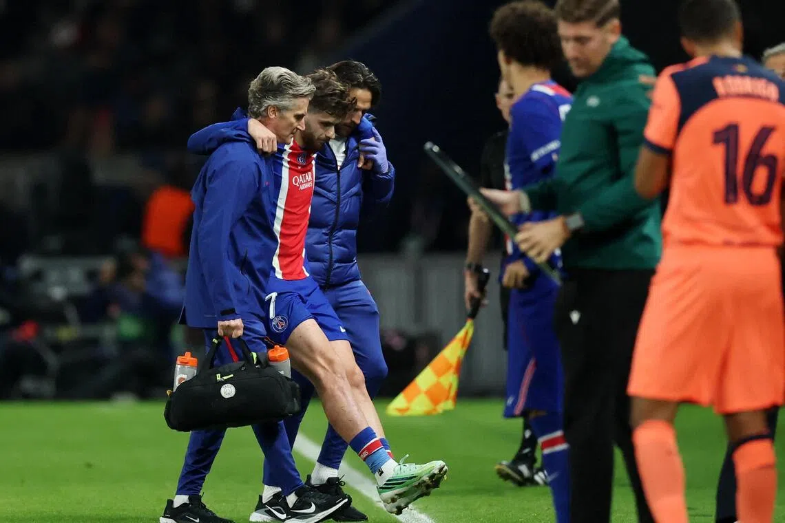 Paris Saint-Germain’s Khvicha Kvaratskhelia leaves the pitch after sustaining an injury during the 4-2 Champions League win over Barcelona.