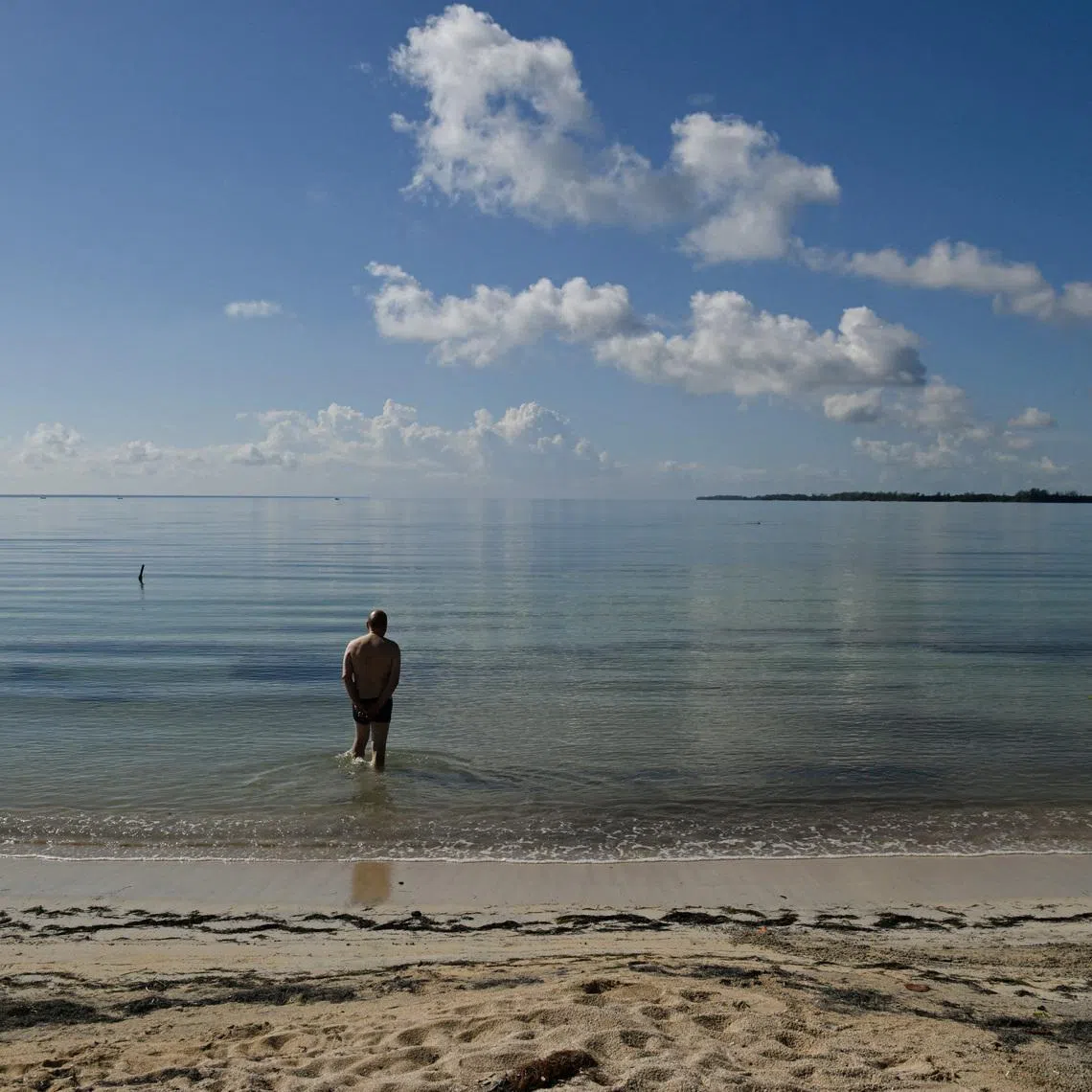 A German tourist walks into the water as Cuba's top tourist destinations remain deserted amid power and fuel shortages under U.S. sanctions, with international tourist arrivals plunging 56 per cent in February from a year earlier, in Playa Larga, Cienaga de Zapata, Cuba, April 8, 2026. REUTERS/Norlys Perez