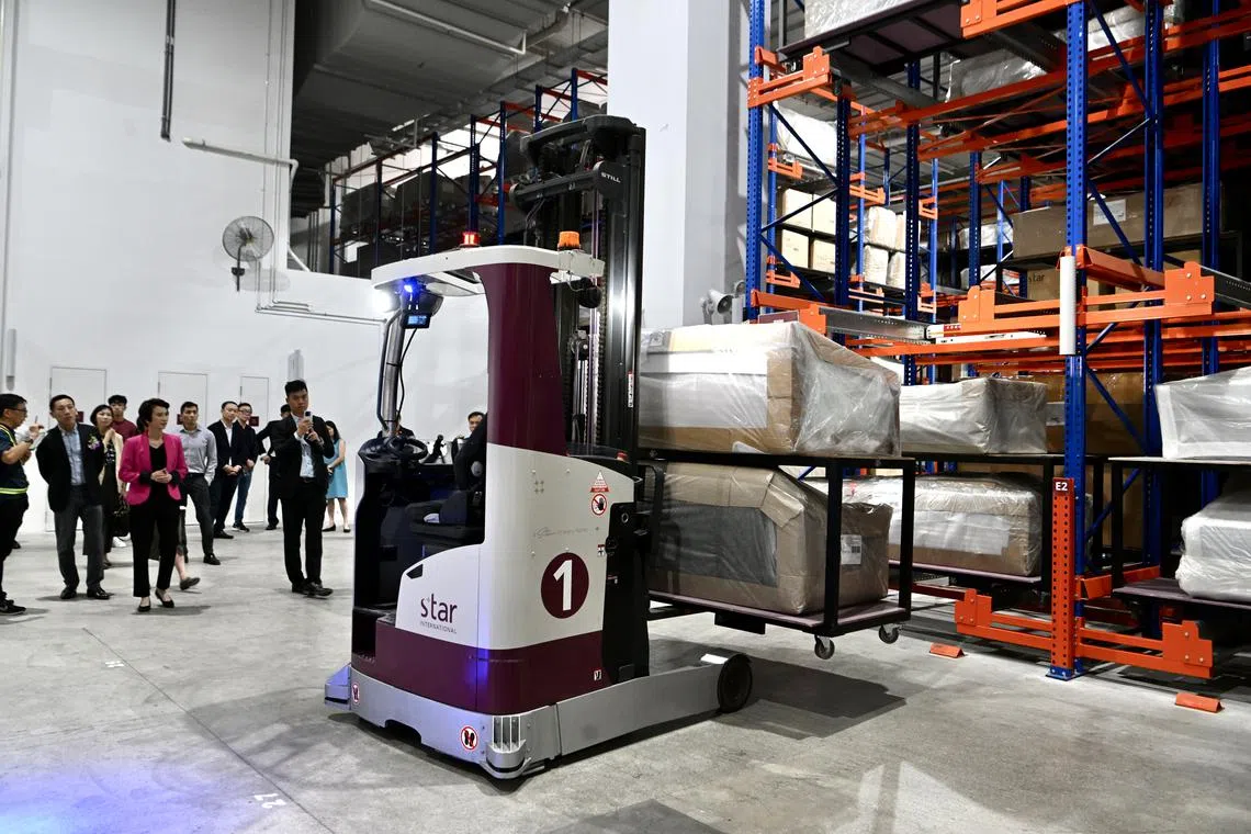 The autonomous-guided vehicles use sensors to navigate and pick up heavy furniture throughout the facility.