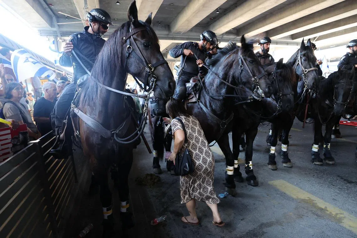 Mounted Israeli security forces were deployed before anti-government protesters during a demonstration at Ben Gurion Airport near Lod on July 3, 2023. Hundreds of protesters gathered on July 3 at the airport for the latest demonstration against the government and its planned legal reform. Blowing horns, banging drums and holding placards reading "Democracy will win," the crowd blocked the access of vehicles to the airport's main international arrival and departure terminal. 