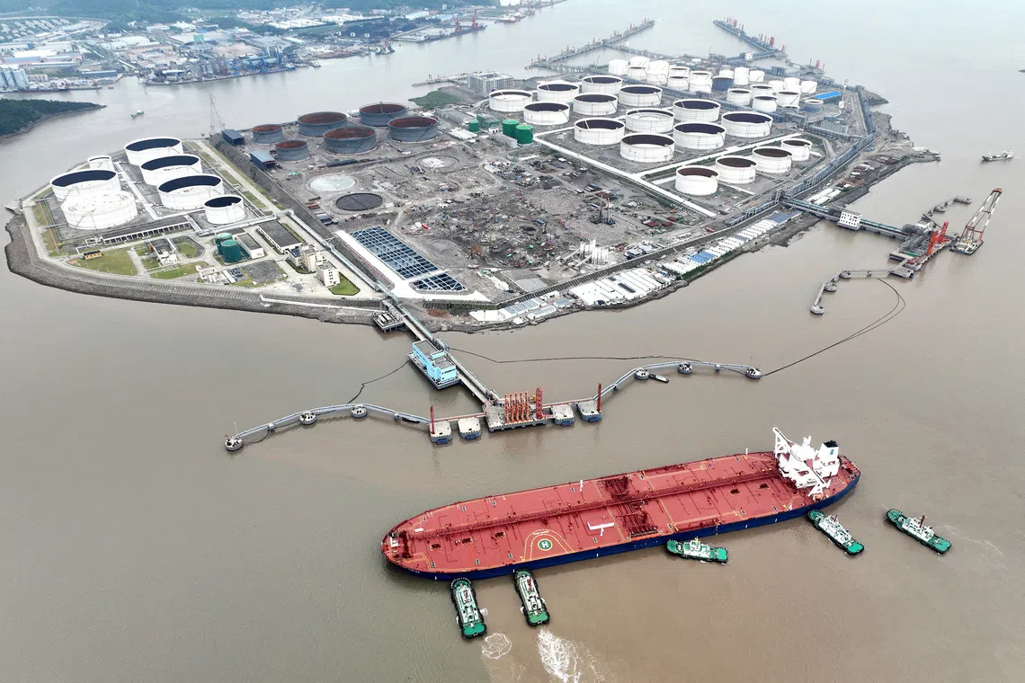 FILE PHOTO: An aerial view shows tugboats helping a crude oil tanker to berth at an oil terminal, off Waidiao Island in Zhoushan, Zhejiang province, China July 18, 2022. cnsphoto via REUTERS/File Photo