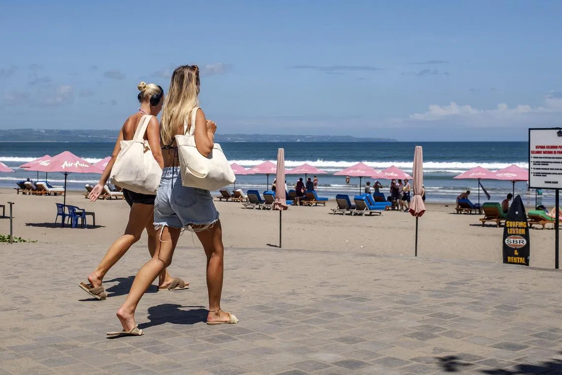 epa11313850 Foreign tourists walk at a beach in Seminyak, Bali, Indonesia, 02 May 2024. The number of foreign tourist visits to Indonesia in March 2024 reached 1.04 million, according to the Indonesia Central Agency of Statistics. This figure decreased by 1.91 percent compared to February 2024 (month-to-month) and increased by 19.86 percent compared to the same month last year (year-on-year), according to data released on 02 May 2024.  EPA-EFE/MADE NAGI