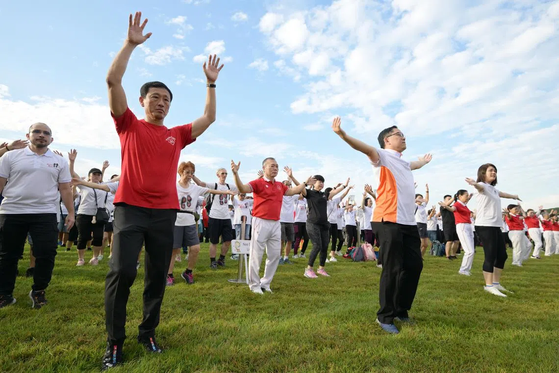 nthealthy01/ST20250601_202533300367/Ng Sor Luan/Minister of Health, Ong Ye Kung (front row, left) and mayor of North West District, Alex Yam (front row, second from left) warming up before a walk at the Healthy Living Festival @ North West held at the Turf Club on June 1, 2025. This is one of the Turf Club's last events.