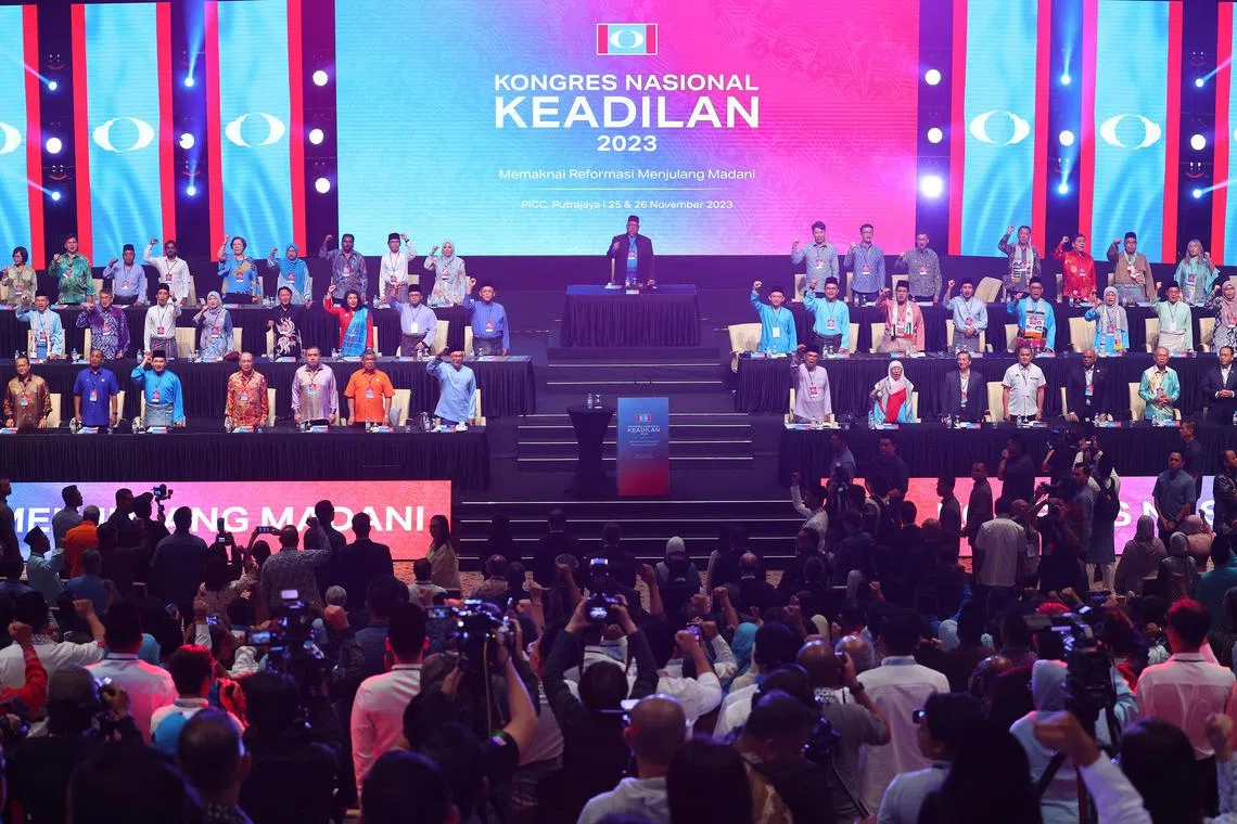 PUTRAJAYA - PM Anwar (front row on stage, seventh from Left, wearing blue) raising his right hand at the annual congress of his PKR party on Nov 25.
