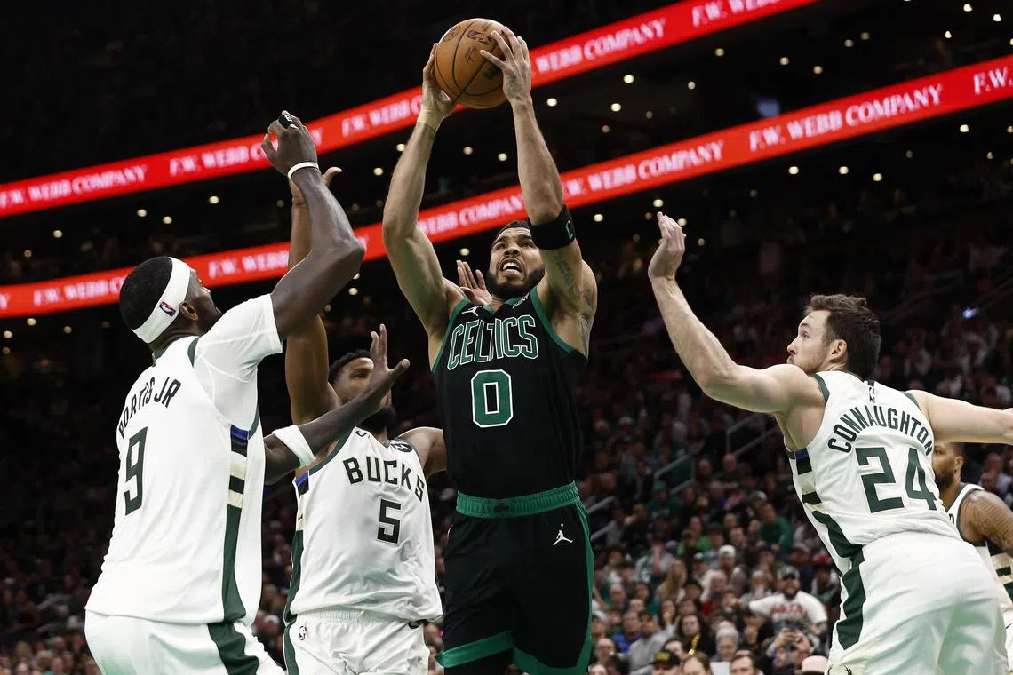 Boston Celtics forward Jayson Tatum drives to the basket between Milwaukee Bucks guard Pat Connaughton and forward Bobby Portis during the second half at TD Garden.