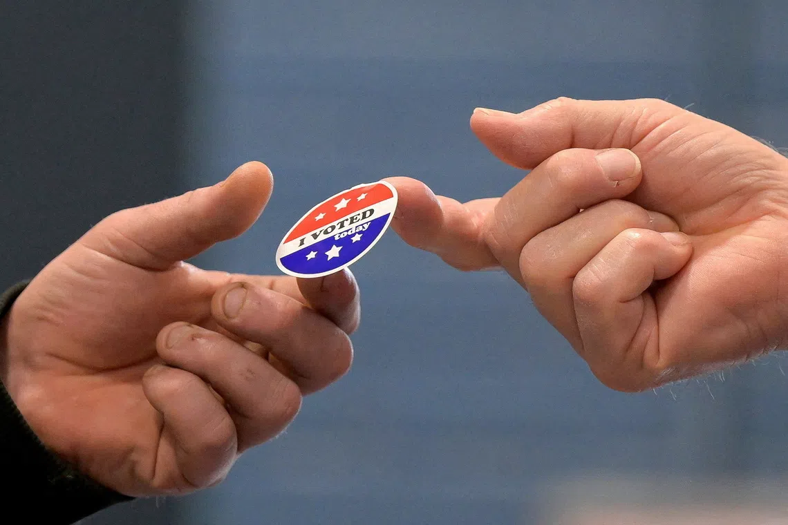 FILE PHOTO: A voter receives a sticker after casting his ballot at New Begin Hall during the 2024 U.S. presidential election on Election Day in Gray, Maine, U.S., November 5, 2024. REUTERS/Faith Ninivaggi/File Photo