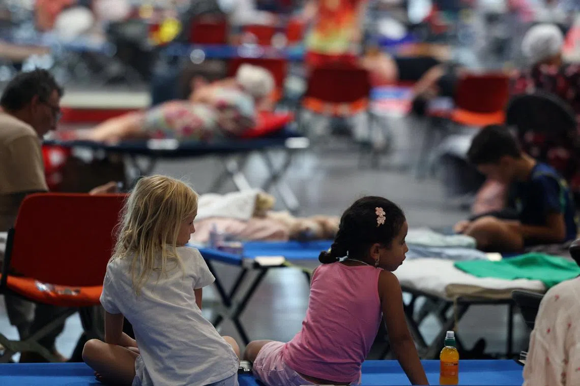 Children rest at the Bordeaux-Lac Exhibition Centre, which has been turned into a shelter for people displaced by a wildfire burning nearby amid worsening drought conditions following a heatwave and water shortages across much of France, in Bordeaux, Gironde, France, July 26, 2026. REUTERS/Florion Goga